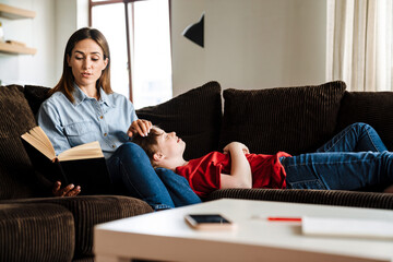 White woman reading book to her daughter with down syndrome