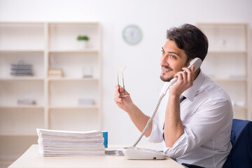 Young male employee unhappy with excessive work in the office