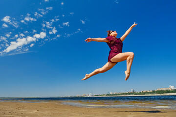 Fototapeta na wymiar Striving for high goals through overcoming yourself. Jumping on the beach in the water.