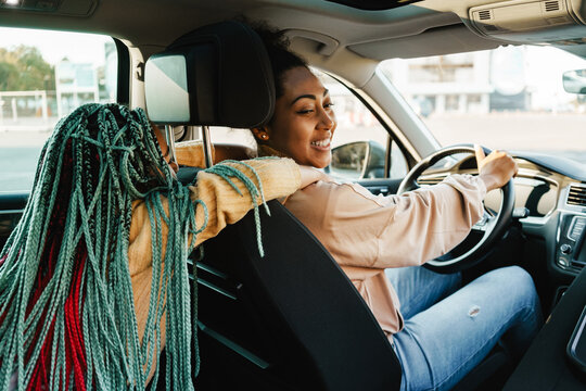 Black Woman And Her Daughter Laughing While Playing In Car