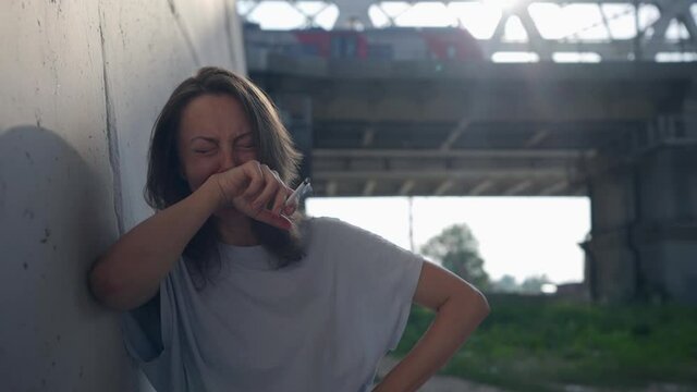 abandoned woman is crying and smoking cigarette outdoors, loneliness and unhappy love