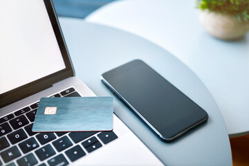 Laptop, electronic chip card and smartphone on blue round table. Paying online or client identification.