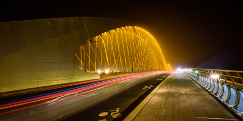 A night view of the Troja Bridge (Trojsky most) with the light trail of cars in Prague, Czech republic. - obrazy, fototapety, plakaty