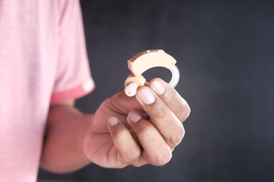 Hand Hold Hearing Aid Equipment Isolated On Black 