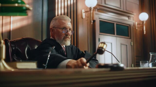 Court of Justice Trial: Portrait of Impartial Judge Reading Decision, Pronouncing Sentence, striking Gavel. Unbiased Judgment after Deliberation Find the Defendant Guilty, Not Guilty Verdict