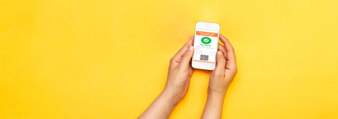 hand woman holding a mobile phone with digital vaccination certificate to certify that have been...