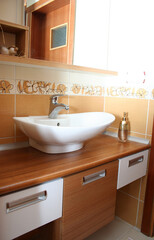 Clean bathroom sink with wooden drawers