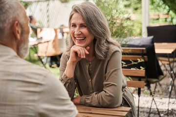 Woman laughing out loud with her beloved husband while discussing something