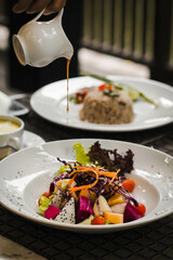 Bowl of healthy fresh fruit salad  with sauce

