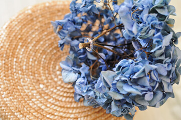 A silver ring on a sprig of blue hydrangea.