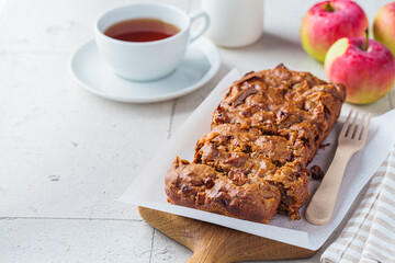 Apple bread on a wooden board. Autumn fruit pie, gray background.