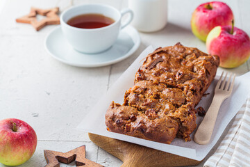 Apple bread on a wooden board. Autumn fruit pie, gray background.