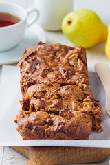 Pear bread on a wooden board. Autumn fruit pie, gray background