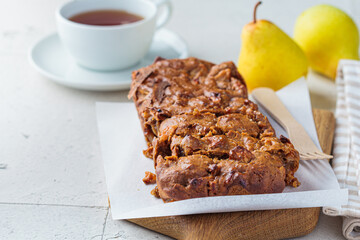 Pear bread on a wooden board. Autumn fruit pie, gray background