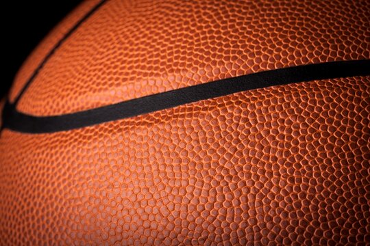 Orange classic basketball with texture on dark background