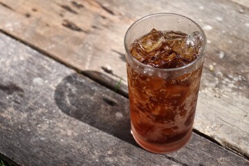 Close up of cola drink and glass on wood table background