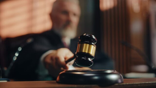 Court of Law and Justice Trial Session: Imparcial Honorable Judge Pronouncing Sentence, striking Gavel. Focus on Mallet, Hammer. Cinematic Shot of Dramatic Not Guilty Verdict. Blurred Slow Motion