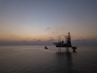 Aerial view offshore drilling rig (jack up rig) at the offshore location during sunrise