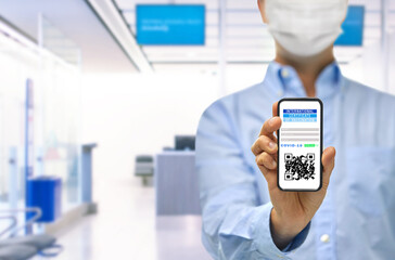 travel, coronavirus and health concept - close up of man in mask holding and showing smartphone with international certificate of covid-19 vaccination on screen over airport lounge background