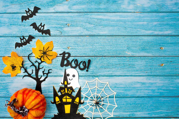 The banner. Modern background with black bats, pumpkins, leaves, cobwebs, spiders, witches and a scary castle on a blue wooden background. Halloween with copy space for text. Flat lay, top.
