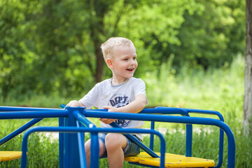 Blonde little boy in a summer park