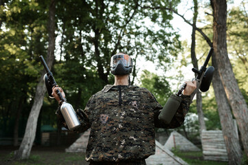 Paintball warrior poses on playground in forest