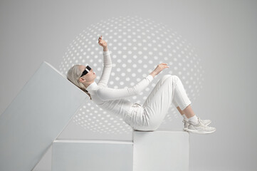 Model in futuristic glasses lying on cubes