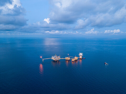 Central processing platform (cpp) in the middle of the ocean during sunset time - upstream industry.