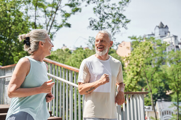 Well shaped retirement couple is jogging at the nature