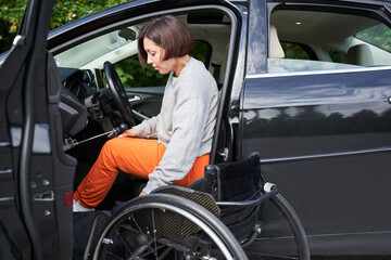Disabled woman sitting on wheelchair boarding into her car