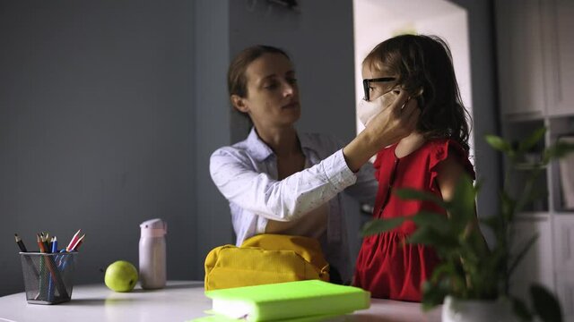 Child Going Back To School. Mother And Kid Getting Ready For First School Day After Vacation. Mom Put A Mask On The Face Of A Little Girl Who Is Going To Go To School.