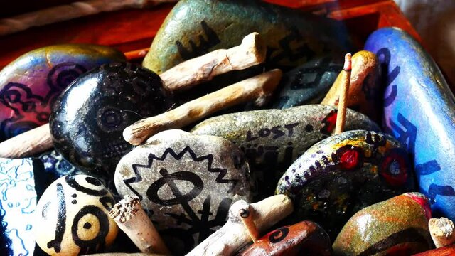 Magical painted Viking drawing patterned spiritual stones colourful art collection in wooden box with burning incense