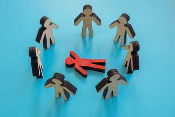 Bullying and inclusion concept. A circle of figures and one lying.