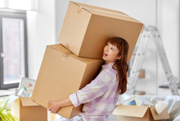moving, people and real estate concept - asian woman holding big heavy boxes with stuff at new home