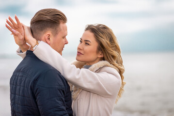 Obraz premium Two Young couple standing enjoying on a coast and enjoying each other.Summer,spring,autumn vacation.