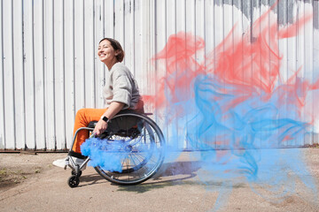 Woman with lower body disability riding at the wheelchair while holding bombs with smoke