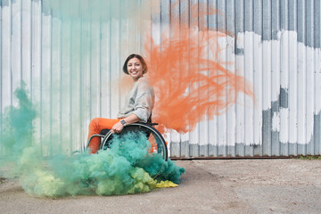 Girl with loss of leg function sitting at the wheelchair and looking at the camera