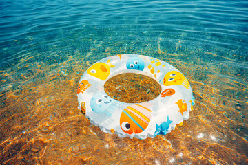 Children buoy in sea water. Swimming ring on the beach.