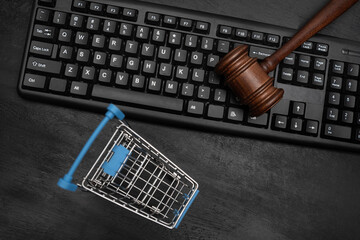 Empty shopping cart and judges hammer on the keyboard. Online Auction.