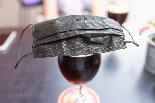 Glass Of Beer,black Face Mask On A Beer Glass Beer On A Table. Coronavirus Restrictions Considering Drinking In Pubs.