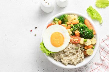 Healthy breakfast savory egg oat vegetables bowl. Space for text, top view.
