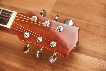 Guitar headstock on wood. Close-up horizontal image.