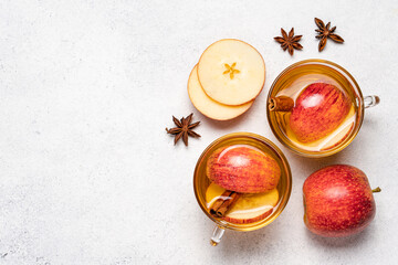 Obraz na płótnie Canvas Apple cider with apple slices, cinnamon and anise stars in transparent cups. Seasonal apple mulled wine, top view