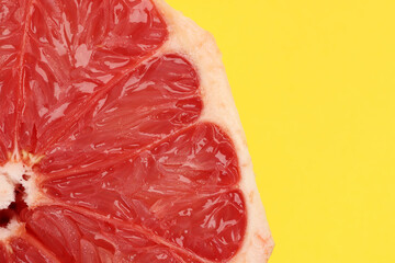 Ruby red grapefruit closeup macro pulp on yellow background