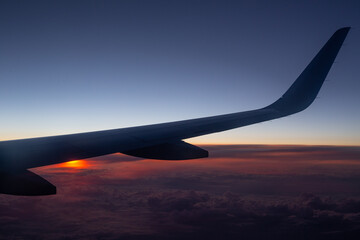 Obraz premium copy space window view of an airplane wing during a sunset with clouds