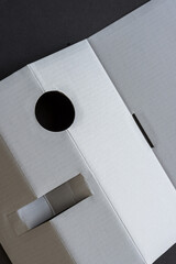 close up of cardboard packing material partly folded with a die cut circle (eye hole)