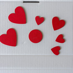 red hearts and a disc on a white cardboard background
