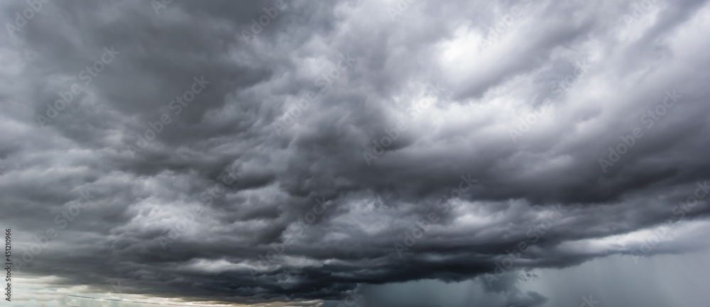 Poster The dark sky with heavy clouds converging and a violent storm before the rain.Bad or moody weather sky.