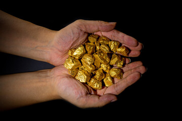 Holding a close-up of a pile of gold bullion, the theme of financial concept