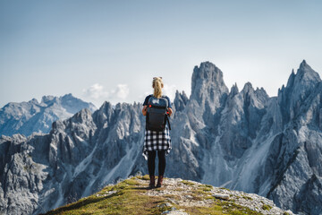 Woman hiker with backpack against Cadini di Misurina mountain group range of Italian Alps, Dolomites, Italy, Europe